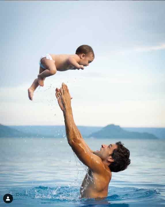 Dad Nico Bolzico playfully lifts baby Tili up in the air