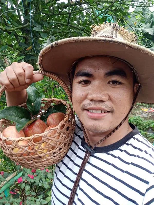 Agriculture student Benzone Kennedy F. Sepe with freshly picking apple fruits