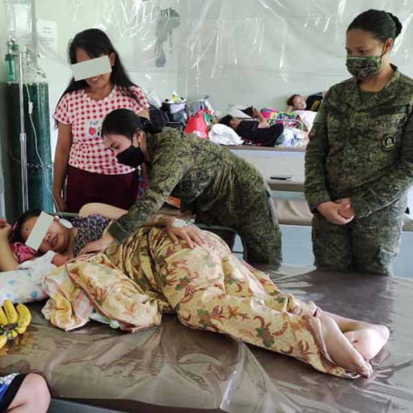 Members of the Philippine Army taking care of former rebel's baby