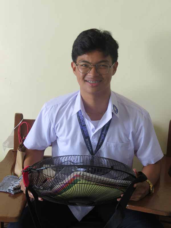 Student carrying an electric fan