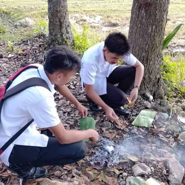Students heating the banana leaves